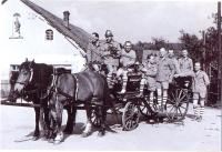 Na návsi v Křivém v roce 1959. Členové sboru odjíždějí na koňské stříkačce na fotbalový zápas hasičů proti sokolům. Zleva: Stanislav Zdráhala, Josef Tichánek, František Kuráň, Josef Konvičný, Alois Beňo, Eduard Zdráhala, Ludvík Šimurda a Rudolf Mužík.